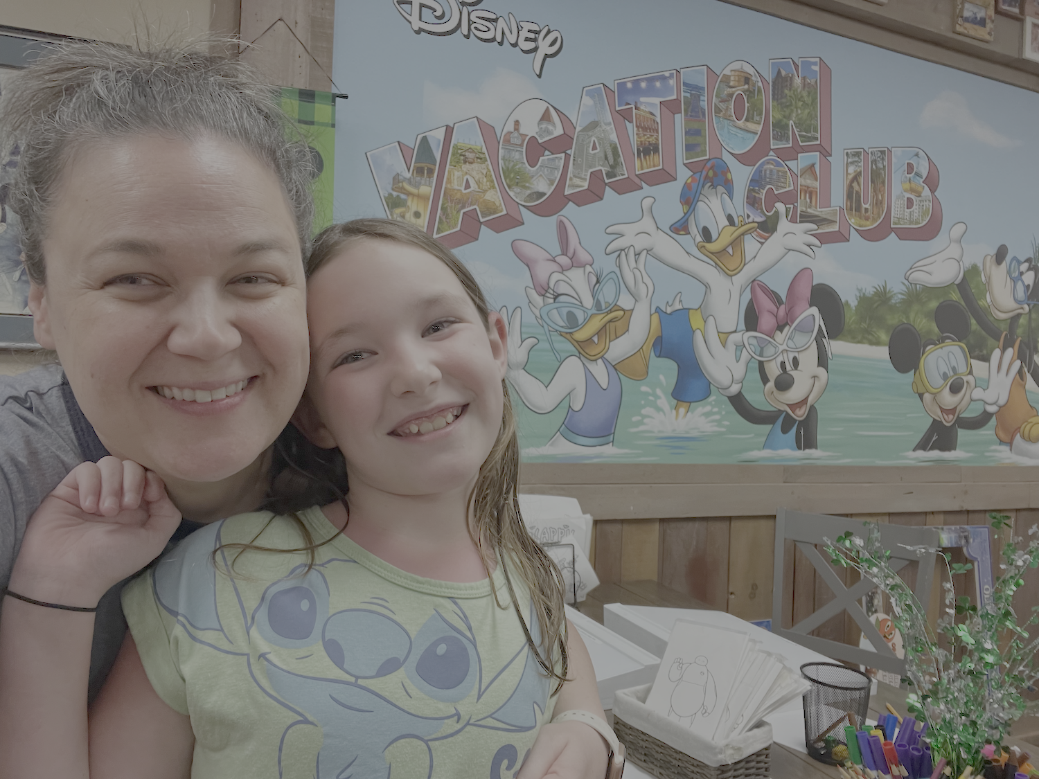 Smiling mom and daughter in front of Disney Vacation Club mural at Walt Disney World